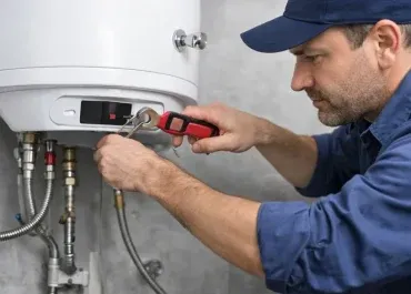 Détails d’un chauffe-eau montrant les opérations d’entretien sans présence humaine : détartrage de la résistance, vérification des raccords et contrôle des fuites d’eau.